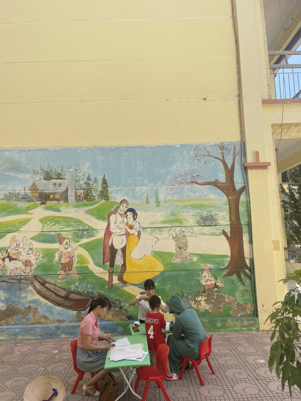 Giáo viên hướng dẫn phụ huynh làm hồ sơ tuyển sinh trực tiếp cho trẻ